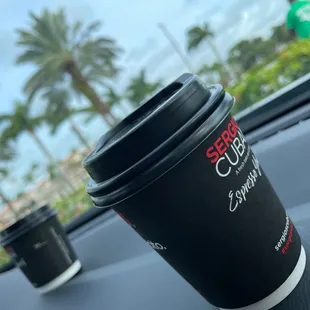 a cup of coffee on the dashboard of a car