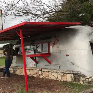 a man standing in front of a taco truck