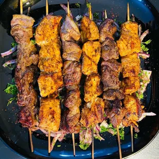 a platter of meat skewered on skewers