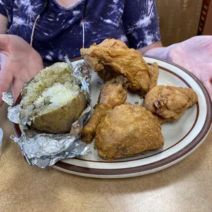 Fried chicken a little undercooked. Baked potato