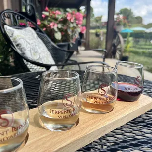 four glasses of wine on a wooden tray