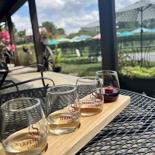 three glasses of wine on a wooden tray