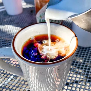 a person pouring milk into a cup