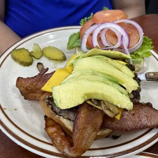 a plate of bacon, avocado, and pickles