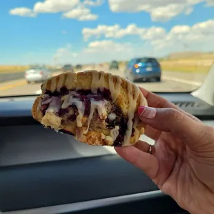 a hand holding a half eaten sandwich