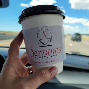 a hand holding a cup of coffee