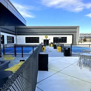 Two Outdoor Pickleball Courts with Nearby Seating and Fire Pit