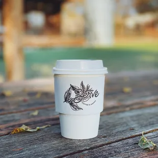 a coffee cup on a picnic table