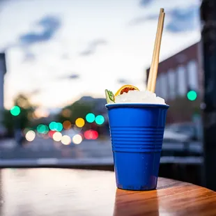 a blue cup of ice cream with a straw in it
