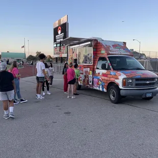 a group of people standing in front of an ice cream truck