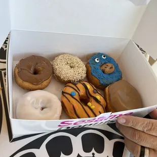 a woman holding a box of donuts