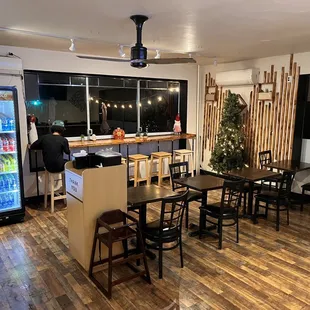a restaurant with a wood floor and a refrigerator