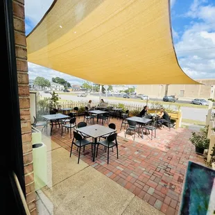 a view of a patio with tables and chairs
