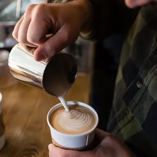 a man pouring a cup of coffee