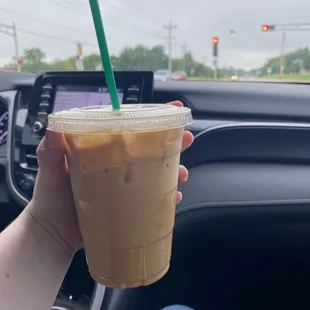 a hand holding a cup of iced coffee