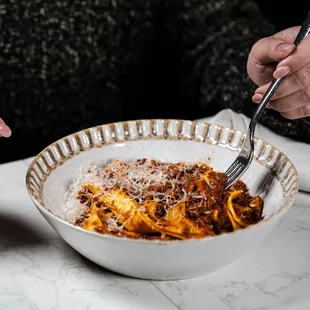 a woman eating a bowl of pasta
