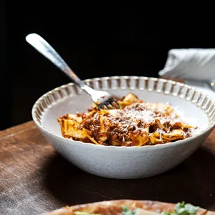 a bowl of pasta and a pizza