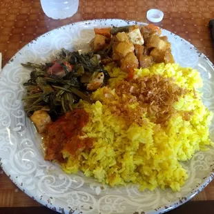 Greens and tofu over yellow rice, with red sambal