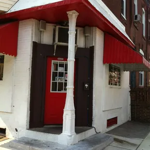 a red and white building with a red awning