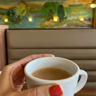 a person holding a cup of coffee