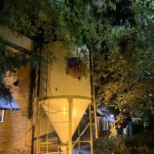 Under the trees, a sign that beer is brewed here.