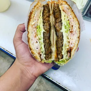 a hand holding a sandwich