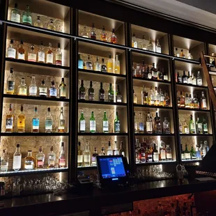 a wall of liquor bottles in a bar