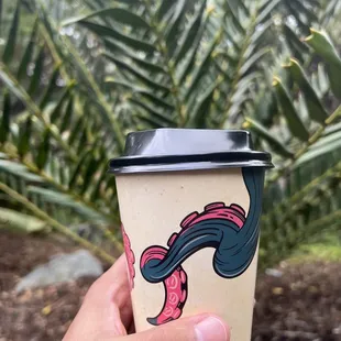 a hand holding a coffee cup