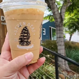 a hand holding a cup of iced coffee