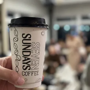a hand holding a cup of coffee