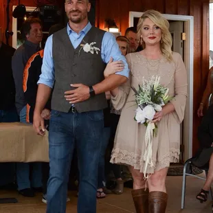 a bride and groom walking down the aisle