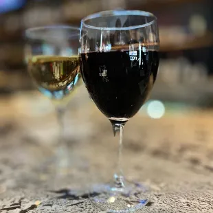 two glasses of wine on a bar