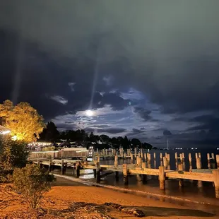 a pier at night with a full moon in the sky