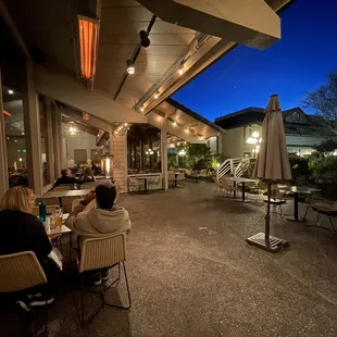 Outdoor patio with overhead heaters and standing fire lamps