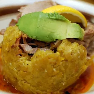 Roasted pork mofongo (mashed fried green plantaines mixed with bacon and garlic,roasted pork ,avocado and a sofrito sauce.