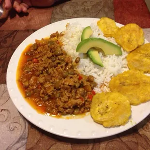 A chili made Puerto Rican style with green pigeon peas ,sofrito and cayenne pepper served with rice , tostones and avocado