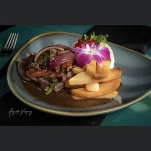 Lomo saltado ( sautéed and flamed beef with tomato onion and French fries )