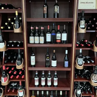 shelves of wine bottles and wine glasses