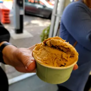 a person holding a cup of ice cream