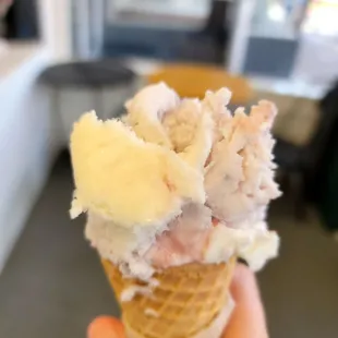 a hand holding a cone of ice cream