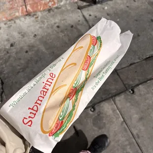 a sandwich wrapped in a paper bag