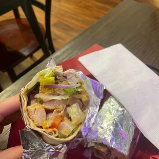 a person holding a wrap of food
