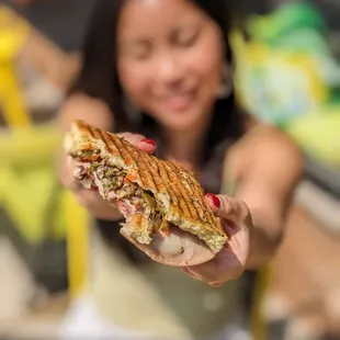 a woman holding a sandwich