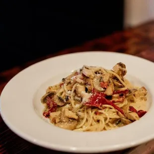 a plate of pasta with mushrooms and peppers