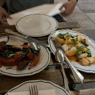 a table with plates of food and utensils