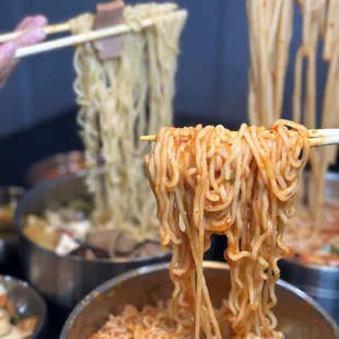 noodles being lifted by chopsticks