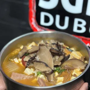 a person holding a bowl of soup