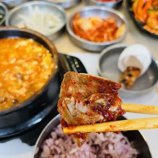 a person holding chopsticks over a bowl of food