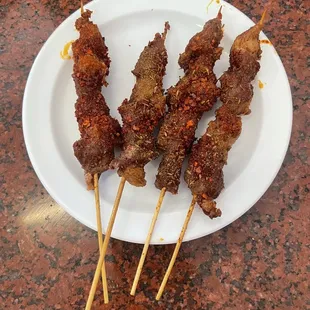 a plate of skewered meat