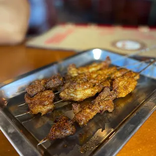 skewered chicken on a metal tray